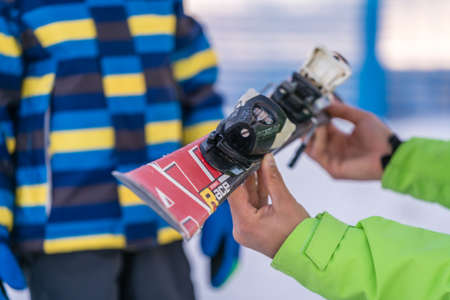 Szklarska Poreba, Poland - February 2019 : Ski instructor holding little boy skis and explaining him...