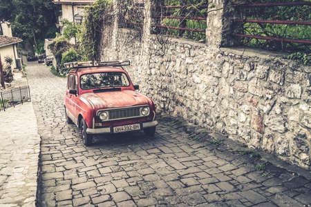 Ohrid, Northern Macedonia -  April 2019 : Small retro vintage old red car slowly climbing up on a...