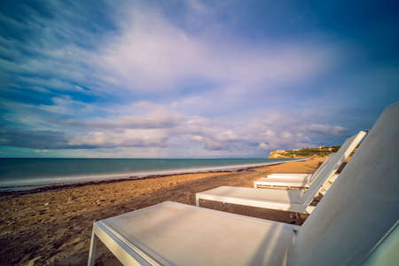 Empty white plastic sunbeds on Tsilivi Beach in summer on Zante Island, Greece