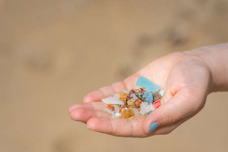 Little girl holding small tiny harmful plastic microbeads collected on the beach in Zante, Zakynthos, Greeceの写真素材