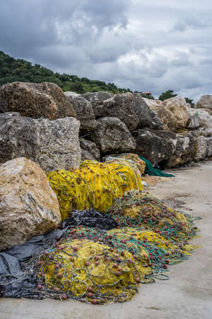 Tangled yellow fisherman fishing nets left abandoned and piled up on the shore of in Zante Island, Greeceの写真素材