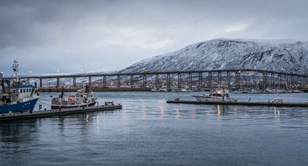 Tromso, Norway -  December 2018 : Port and harbour with famous Tromso Bridge across Tromsoysundet strait in the backgroundのeditorial素材