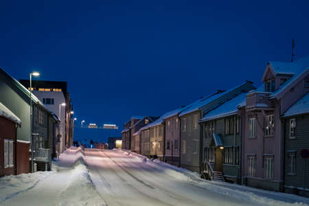 Empty slippery and covered in snow and ice residential street in Tromso at dusk, Norwayの写真素材