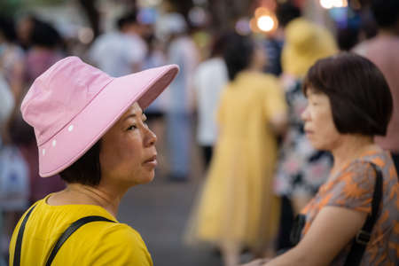 Xian, China -  July 2019 : Chinese tourist woman wearing a pink hat on the street in the Muslim Quarterのeditorial素材