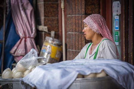 Xian, China -  July 2019 : Muslim woman selling baozi buns and dough on the food street in the Muslim Quarterのeditorial素材