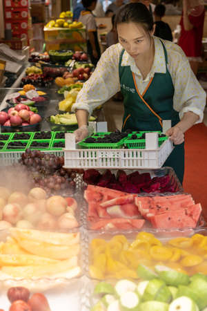 Xian, China -  July 2019 : Female selling freshly cut fruits in a stall in Muslim Quarter in Xian town, Shaanxi Provinceのeditorial素材