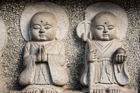 Small holy Buddhist sculptures carved on a temple wall  in Wenshu Monastery, Chengdu, Chinaの写真素材