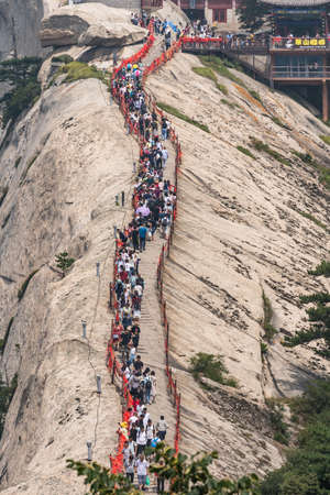 Huashan, China -  August 2019 : Crowds of tourists walking on a narrow ridge on a mountain trail to the West Peak on Huashan mountain, Xian, Shaanxi Provinceのeditorial素材