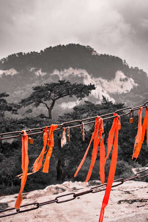Huashan, China -  August 2019 : Red ribbons attached to the protective barrier on a lookout with the stunning mountain landscape view from the summit of West Peak, Huashan mountain, Shaanxi Provinceのeditorial素材