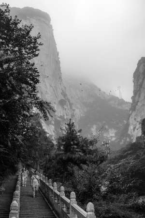 Huashan, China -  August 2019 : Tourists descending the stairs on a steep mountain trail to the North and West Peak on Huashan mountain, Xian, Shaanxi Provinceのeditorial素材