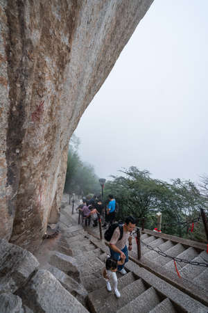 Huashan, China -  August 2019 : Tourists climbing up and descending the stairs on a steep mountain trail to the North and West Peak on Huashan mountain, Xian, Shaanxi Provinceのeditorial素材
