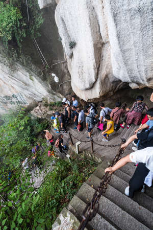 Huashan, China -  August 2019 : Tourists climbing up and descending the stairs on a steep mountain trail to the North and West Peak on Huashan mountain, Xian, Shaanxi Provinceのeditorial素材