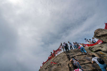 Huashan, China -  August 2019 : Crowds of tourists walking on a mountain trail to the summit of a West Peak on Huashan mountain, Xian, Shaanxi Provinceのeditorial素材