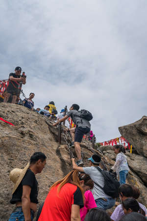 Huashan, China -  August 2019 : Crowds of tourists walking on a mountain trail to the summit of a West Peak on Huashan mountain, Xian, Shaanxi Provinceのeditorial素材