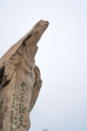 Huashan, China -  August 2019 : Huge tall rock formation with chinese characters inscription painted on it on the scenic mountain trail to the North and West Peak on Hua shan mountain, Xian, Shaanxi Provinceのeditorial素材
