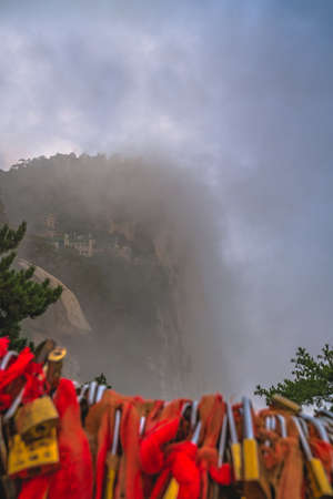 Buddhist temple covered in fog and mist as seen from the summit of South Peak on Huashan mountain, Xian, Shaanxiの写真素材