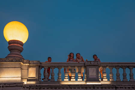 Guilin, China -  August 2019 : Mother with her children looking down from the road Bridge over the estuary of Rong and Shan Lakes at night, Guilin town, Guangxi Provinceのeditorial素材