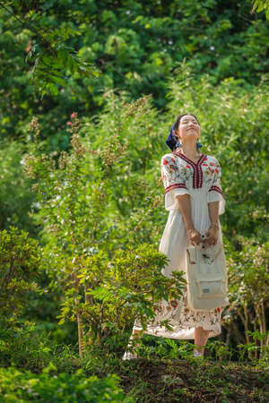 Guilin, China -  August 2019 : Chinese woman dressed in a traditional costume posing for a photograph in a public park in Guilin in summerのeditorial素材