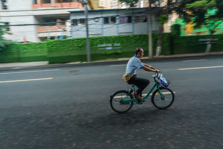 Chengdu, China -  July 2019 : Chinese man cycling on a on an empty street in townのeditorial素材