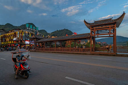 Wulingyuan, China -  August 2019 : Chinese man riding on a motorbike on a street in the ancient part of Wullingyuan townのeditorial素材