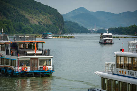Guilin, China - August 2019 : Sightseeing boats full of tourists departing on a trip on the magnificent Li river from Guilin to Yangshuoのeditorial素材