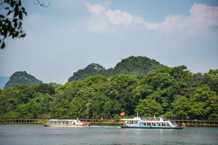 Guilin, China -  August 2019 : Small local passenger boats sailing on the magnificent Li river from Guilin to Yangshuoのeditorial素材