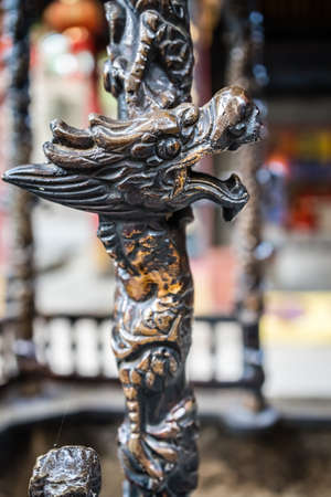 Close up of a dragon head sculpture decoration on a wooden stick, Buddhist Temple wall in Huashan town, Shaanxi Province, Chinaの写真素材