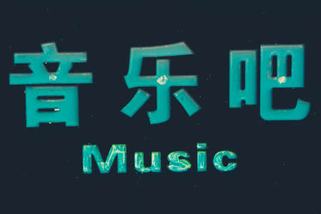 Sign with green chinese characters spelling "music bar" information outside club with live performances and showsの写真素材