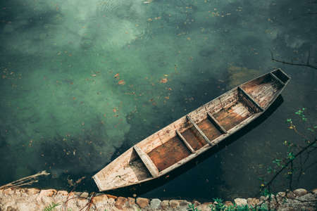 Small old wooden boat on the riverbank in Wellingyuan, Chinaの写真素材