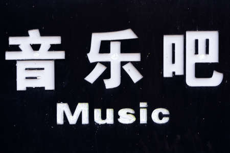 Sign with white chinese characters spelling "music bar" information outside club with live performances and showsの写真素材