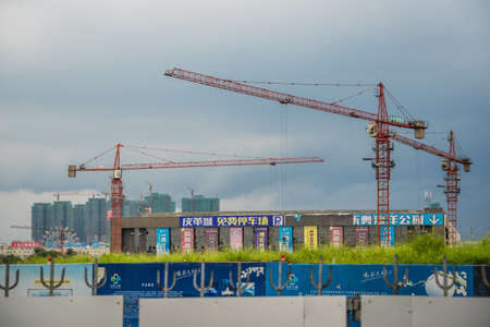 Zigong, China -  July 2019 : Tall cranes on a working construction building site, Sichuan Provinceのeditorial素材