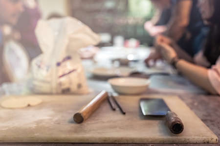 Chengdu, China -  July 2019 : Chopping boards, knife, rolling pin and packet of Chinese flour which will be used for the making of traditional chinese dumplings during cooking class in a travellers hostelのeditorial素材