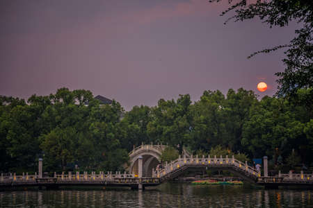 Guilin, China -  August 2019 : Arched bridge and walkway on a lake Shan Lake in the evening, Guilin town, Guangxi Provinceのeditorial素材