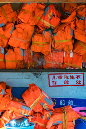 Yangshuo, China - August 2019 : Pile of life vests for passengers on the ferry across Li River in Yangshuo, Guangxi Provinceのeditorial素材