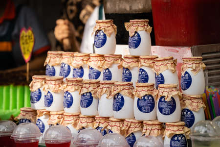 Xian, China -  July 2019 : Small glass container bottles with freshly made yoghurt for sale on the food street in the Muslim Quarterのeditorial素材