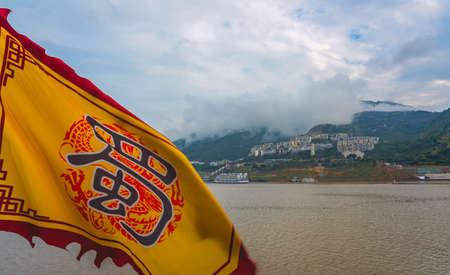 Yangtze River, China - August 2019 : Yellow flag with a chinese symbol character on a cruise boat ship sailing on a Yangtzy river in Chinaのeditorial素材