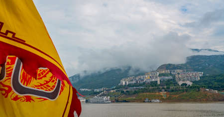 Yangtze River, China - August 2019 : Yellow flag with a chinese symbol character on a cruise boat ship sailing on a Yangtzy river in Chinaのeditorial素材