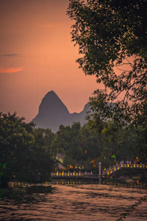 Guilin, China -  August 2019 : Sun setting over the karst mountains landscape and  Shan Lake, Guilin town, Guangxi Provinceのeditorial素材