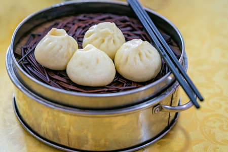 Delicious traditional chinese Baozi buns, steamed buns filled with ground pork meat and cabbage...