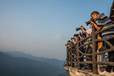 Pingan, China -  August 2019 : Group of photographers waiting for the ideal moment to photograph the...