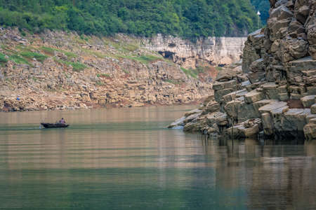 Yangtze River, China - August 2019 : Man in a small fisherman boat on the Shennong Xi Stream, estuary of the mighty Yangtze river, Hubei Provinceのeditorial素材