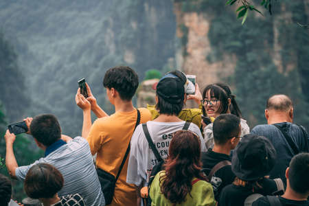 Zhangjiajie, China - August 2019 : Tourists taking pictures on mobile phones on the viewpoint in Tianzi mountain range, Avatar mountains nature parkのeditorial素材