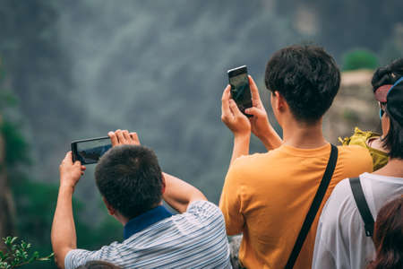 Zhangjiajie, China - August 2019 : Tourists taking pictures on mobile phones on the viewpoint in Tianzi mountain range, Avatar mountains nature parkのeditorial素材