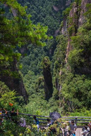 Zhangjiajie, China - August 2019 : Tourists taking pictures on mobile phones on the viewpoint of the Greatest Natural Bridge also known as Tian Qiao Sky Bridge, Avatar mountains nature parkのeditorial素材