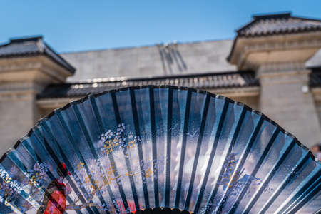 Chinese fan spread out with the building in Terracota Warriors Museum in the background, Xian town, Chinaの写真素材