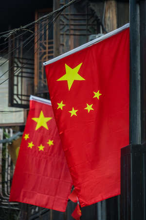 Chinese flag flutering above narrow street in the Old town of Fenghuang, known as Phoenix town, Hunan Province, Chinaの写真素材