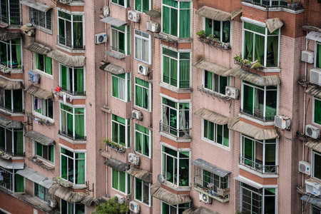 Zigong, China - July 2019 : Windows and balconies of old residential buildings, blocks of flats and...