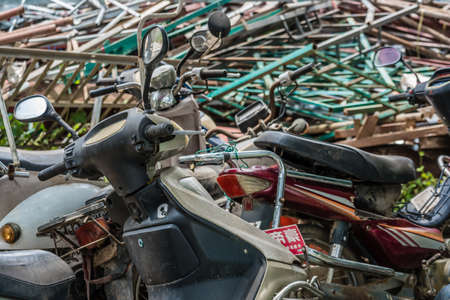 Yangshuo, China - August 2019 : Used, old, damaged and disposed of motorbikes, motorcycles and scooters piled up in the yard outside metal recycling plant in Yangshuo, Guangxi Provinceのeditorial素材