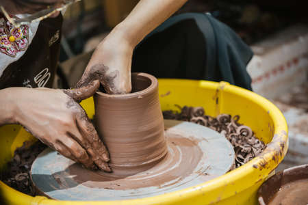 Chongqing, China - August 2019 : Female worker sitting in a workshop making ceramic pottery for sale, Ci Qi Kou Old townのeditorial素材