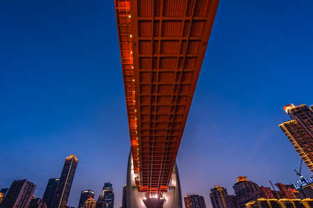 Chongqing, China -  August 2019 : Illuminated DongShuiMen road bridge over and across mighty Yangtze...